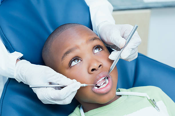 Close up of boy having his teeth examined by a dentist